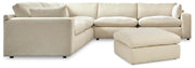 Ashley Furniture Elyza living room set with sofa, loveseat, and armchair in neutral upholstery, arranged in a modern living space.