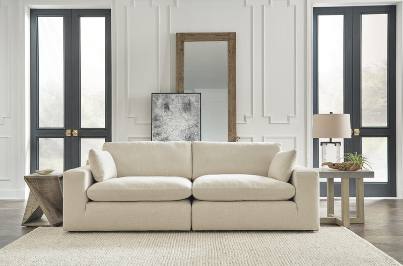 Ashley Furniture Elyza living room set with sofa, loveseat, and armchair in neutral fabric, arranged in a modern living space.