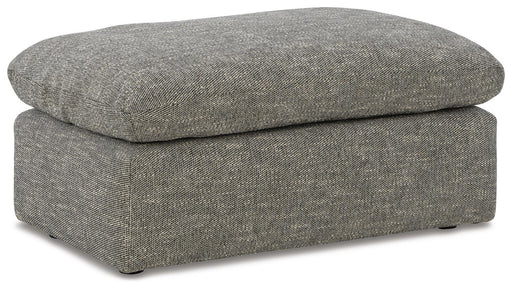 Ashley Furniture dramatic ottoman with a plush fabric cover, shown from an angled perspective in a stylish living room setting.