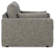 Oversized Ashley Furniture chair with dramatic design, featuring plush upholstery and wide armrests, viewed from the side.