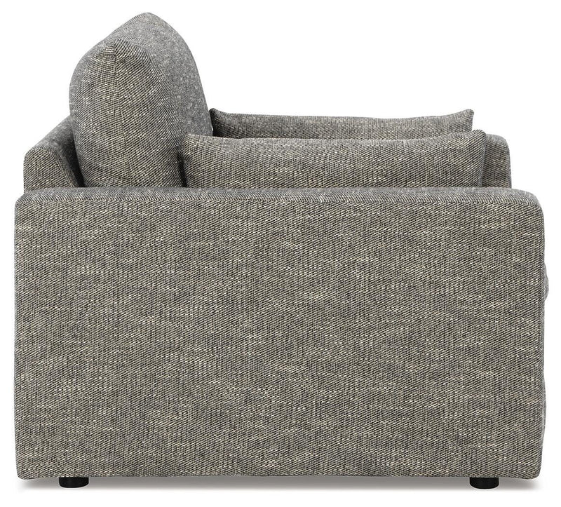 Oversized Ashley Furniture chair with dramatic design, featuring plush upholstery and wide armrests, viewed from the side.