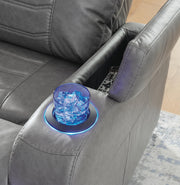 Ashley Furniture Schooner Rocks power recliner with armrest, storage, cup holder, and headrest in a modern living room setting.