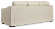 Ashley Furniture Treasure Trove sofa with plush cushions and dark wood legs, shown from the back in a modern living room setting.