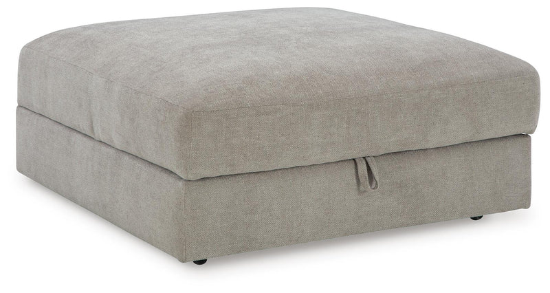 Ashley Furniture Aslan Court Ottoman with storage, upholstered beige fabric, open top, and wooden legs, shown from an angle.