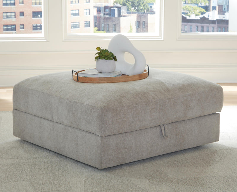 Ashley Furniture Aslan Court Ottoman with storage, upholstered fabric, and wooden legs, shown closed in a modern living room setting.