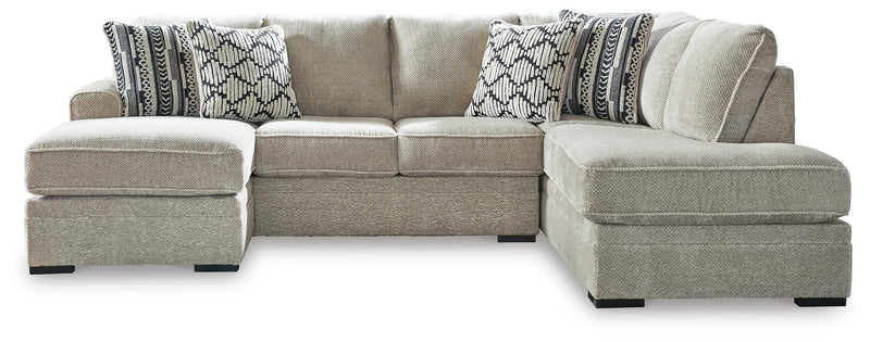 Ashley Furniture Calnita sectional with chaise showing plush fabric upholstery and modern design in a spacious living room setting.