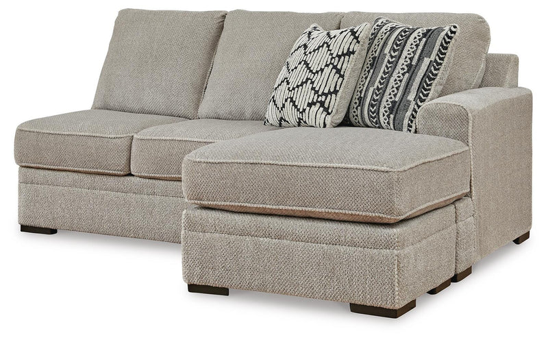Ashley Furniture Calnita sectional with chaise, showing a modern fabric sofa with multiple cushions and a spacious design.