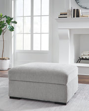 Ashley Furniture Gabyleigh Ottoman with storage, beige fabric with tufted top and wooden legs, serving as a stylish living room accent piece.