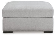 Ashley Furniture Gabyleigh storage ottoman with cushioned top and wooden legs, shown from a head-on angle.