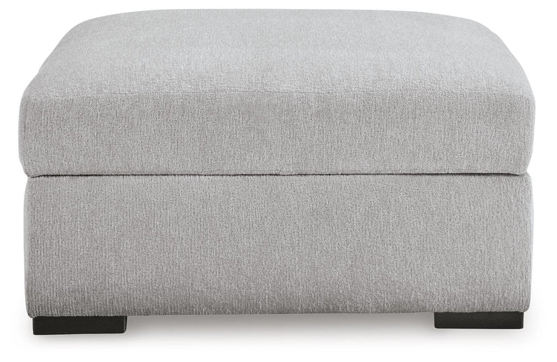 Ashley Furniture Gabyleigh storage ottoman with cushioned top and wooden legs, shown from a head-on angle.