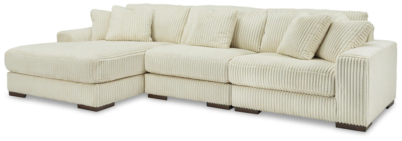 Ashley Furniture Lindyn sectional with chaise, beige fabric, and plush cushions, showcasing a modern living room setup.