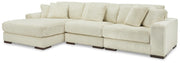 Ashley Furniture Lindyn living room set with a sofa, loveseat, and armchair in neutral upholstery, arranged in a modern living space.