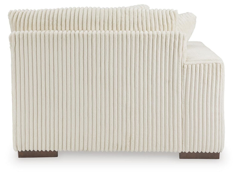 Ashley Furniture Lindyn sectional with chaise showing beige fabric upholstery and plush cushions in a modern living room setting.