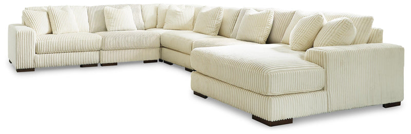 Ashley Furniture Lindyn sectional with chaise, showing a modern fabric sofa with a spacious chaise lounge in a living room setting.