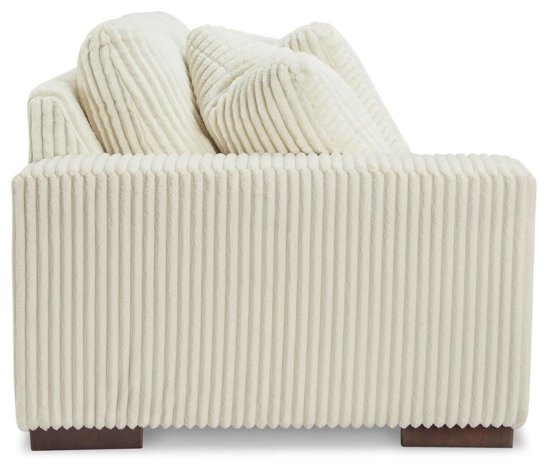 Ashley Furniture Lindyn sectional with chaise, featuring neutral fabric upholstery and plush cushions in a modern living room setting.