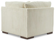 Ashley Furniture Lindyn sectional with chaise, showing a cozy fabric sofa with a chaise lounge, in a modern living room setting.