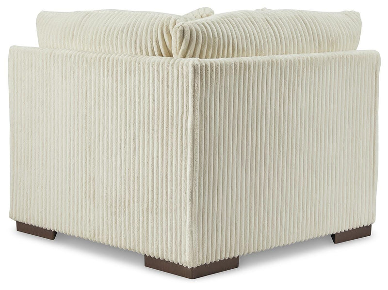 Ashley Furniture Lindyn sectional with chaise, showing a cozy fabric sofa with a chaise lounge, in a modern living room setting.