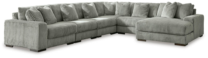 Ashley Furniture Lindyn sectional with chaise, showing beige fabric upholstery and plush cushions in a modern living room setting.