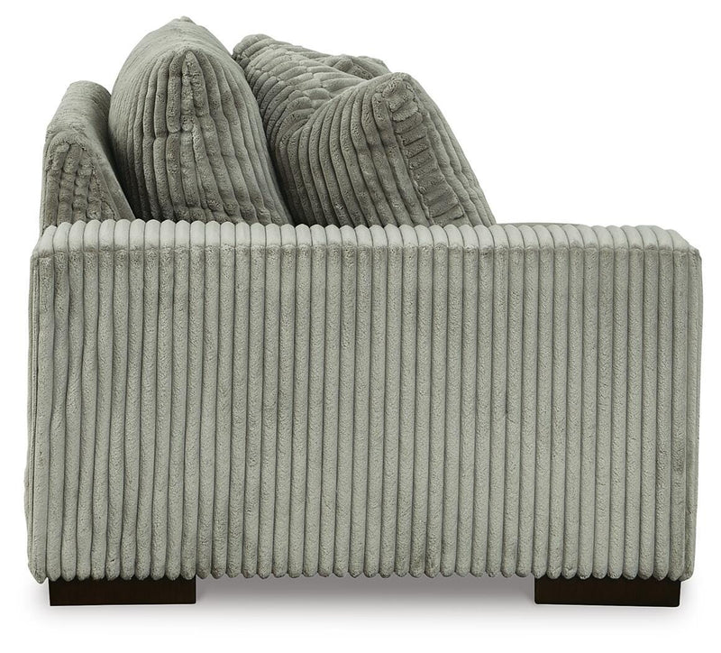 Ashley Furniture Lindyn sectional with chaise showing beige fabric upholstery and modern design in a living room setting.