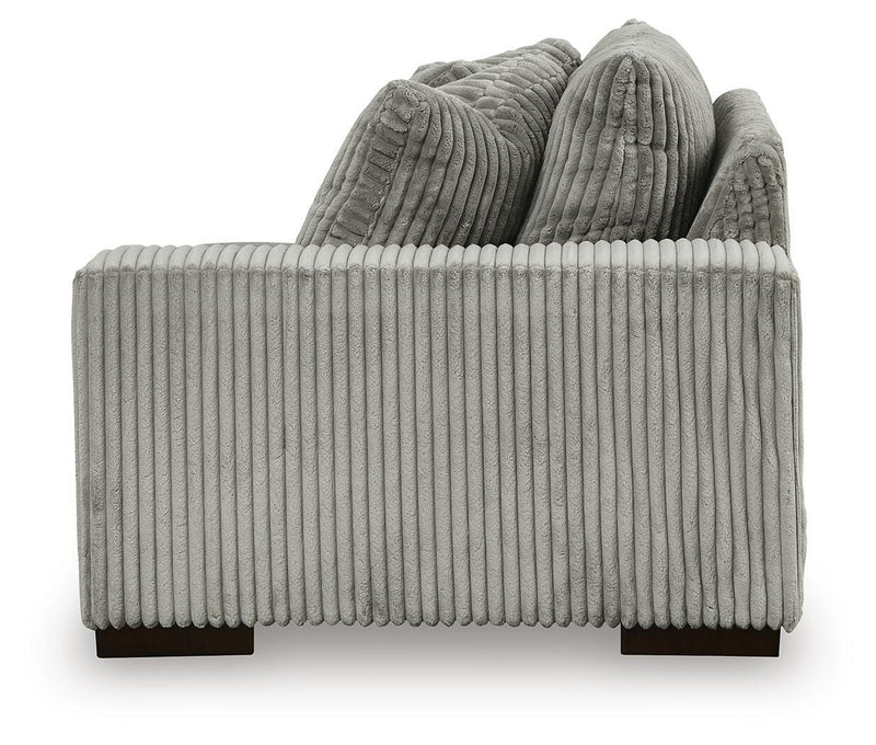 Ashley Furniture Lindyn sectional with chaise, featuring plush fabric and modern design, shown with a side view.