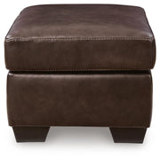Ashley Furniture Santorine Ottoman with tufted fabric and wooden legs, shown from a side angle.