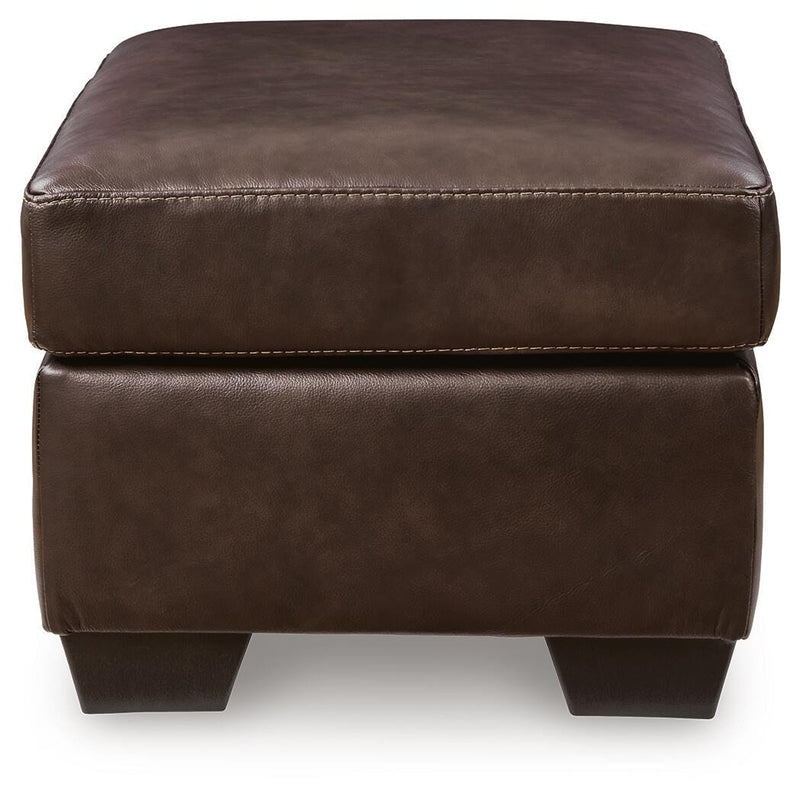 Ashley Furniture Santorine Ottoman with tufted fabric and wooden legs, shown from a side angle.