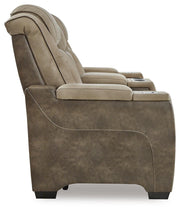 Ashley Furniture Next-Gen DuraPella power reclining loveseat with console, shown from the side with plush cushions and built-in cup holders.