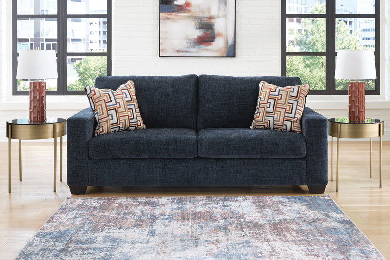 Ashley Furniture Aviemore Sleeper Sofa with plush fabric, featuring a fold-out bed and modern design, shown in a living room setting.
