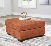 A large Ashley Furniture Aviemore oversized accent ottoman with plush fabric and a sturdy wooden base in a neutral color.