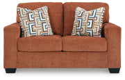Ashley Furniture Aviemore loveseat with plush beige fabric, cushioned armrests, and comfortable seating for two.