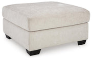Ashley Furniture Aviemore oversized accent ottoman with plush fabric and tufted design, shown from an angled side view.