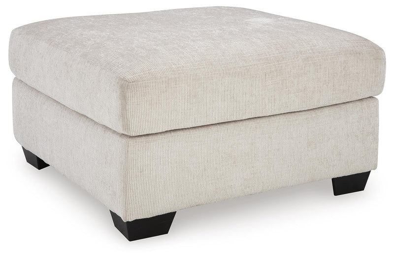 Ashley Furniture Aviemore oversized accent ottoman with plush fabric and tufted design, shown from an angled side view.