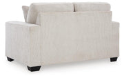 Ashley Furniture Aviemore loveseat with plush fabric and cushioned backrest, shown in a cozy living room setting.