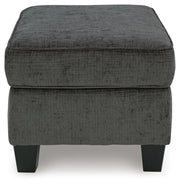 Ashley Furniture Erinslane Ottoman with cushioned top and wooden legs, shown in a stylish living room setting.