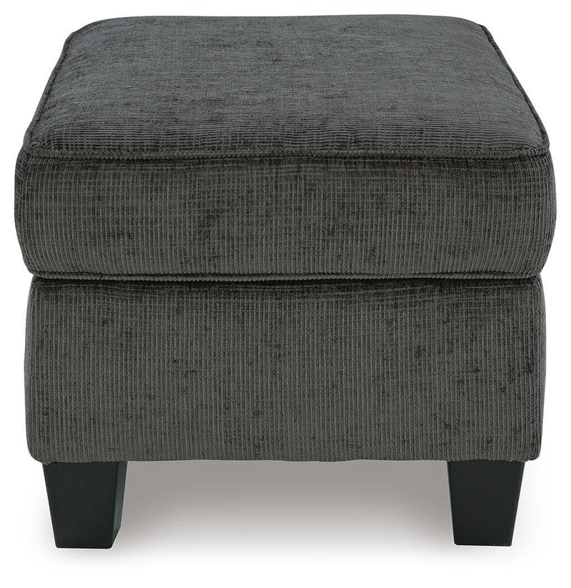 Ashley Furniture Erinslane Ottoman with cushioned top and wooden legs, shown in a stylish living room setting.