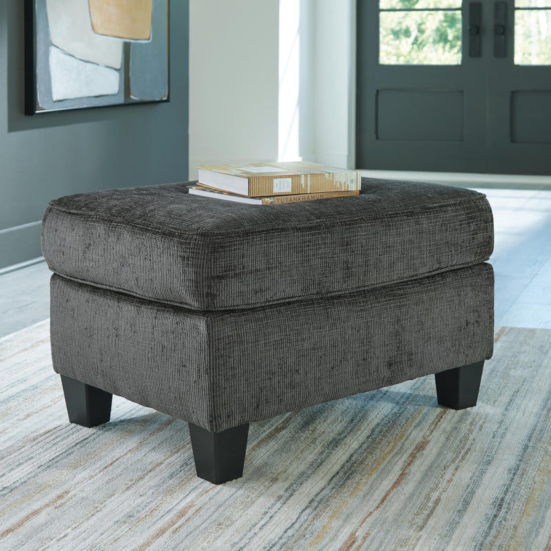 Ashley Furniture Erinslane Ottoman showing a wooden upholstered storage ottoman in a neutral fabric with decorative nailhead trim.