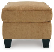 Ashley Furniture Erinslane Ottoman with tufted fabric and wooden legs, shown from a side angle.