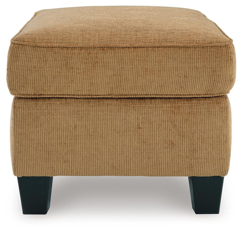 Ashley Furniture Erinslane Ottoman with tufted fabric and wooden legs, shown from a side angle.