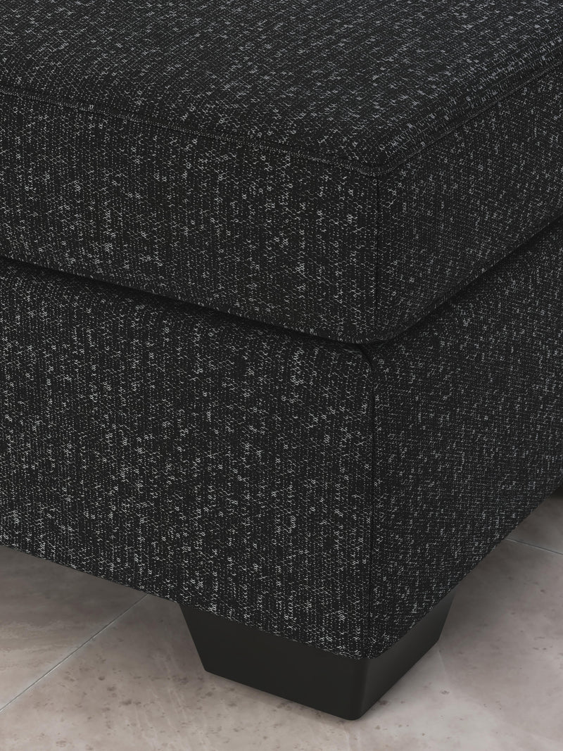 Ashley Furniture Jasmine Peaks Ottoman with plush fabric and wooden legs, shown in a detailed close-up image.