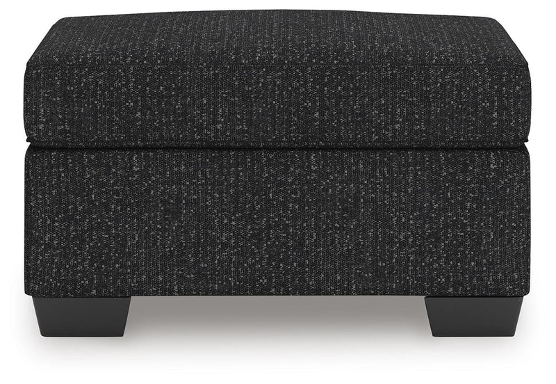 Ashley Furniture Jasmine Peaks Ottoman in neutral fabric, showcasing its plush cushioned top and wooden legs.