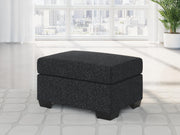Ashley Furniture Jasmine Peaks Ottoman with plush fabric and wooden legs, showcasing a stylish and versatile accent piece for living rooms.