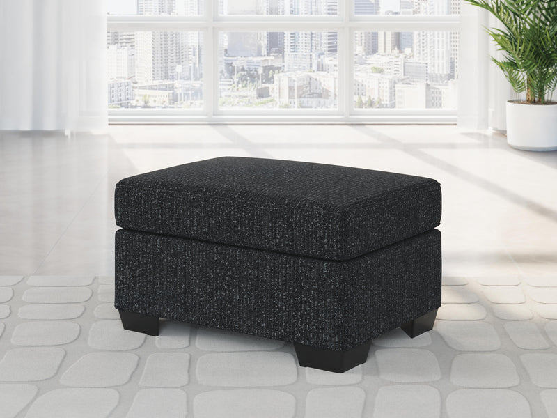 Ashley Furniture Jasmine Peaks Ottoman with plush fabric and wooden legs, showcasing a stylish and versatile accent piece for living rooms.