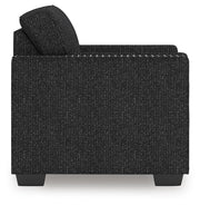 Ashley Furniture Jasmine Peaks chair with plush fabric and wooden legs, shown from the side angle.