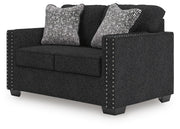Ashley Furniture Jasmine Peaks loveseat shown from an angled side view, featuring plush fabric and cushioned armrests.