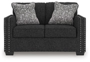 Ashley Furniture Jasmine Peaks loveseat with plush beige upholstery and cushioned armrests, shown from a front head-on angle.