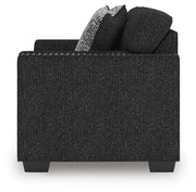 Jasmine Peaks Ashley Furniture loveseat with plush beige fabric and rolled arms, shown in a cozy living room setting.