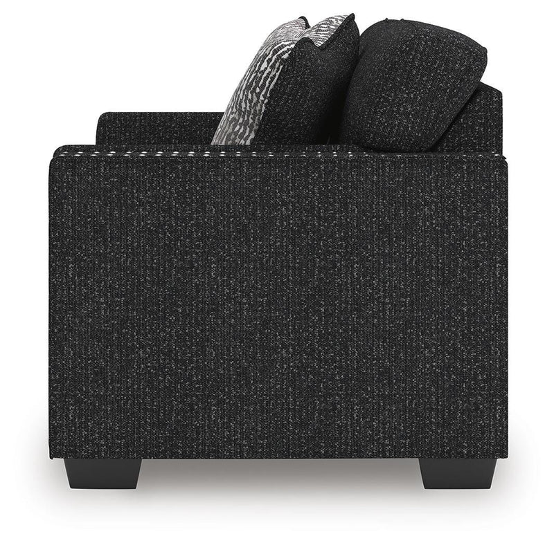 Jasmine Peaks Ashley Furniture loveseat with plush beige fabric and rolled arms, shown in a cozy living room setting.