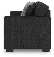 Ashley Furniture Jasmine Peaks sofa with plush cushions and neutral fabric, shown from a side view in a modern living room setting.