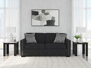 Ashley Furniture Jasmine Peaks Sofa showing plush beige fabric, wide armrests, and cushioned seating in a modern living room setting.