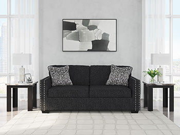 Ashley Furniture Jasmine Peaks Sofa showing plush beige fabric, wide armrests, and cushioned seating in a modern living room setting.